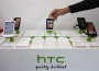 A shop attendant arranges HTC phones in a mobile phone store in Taipei